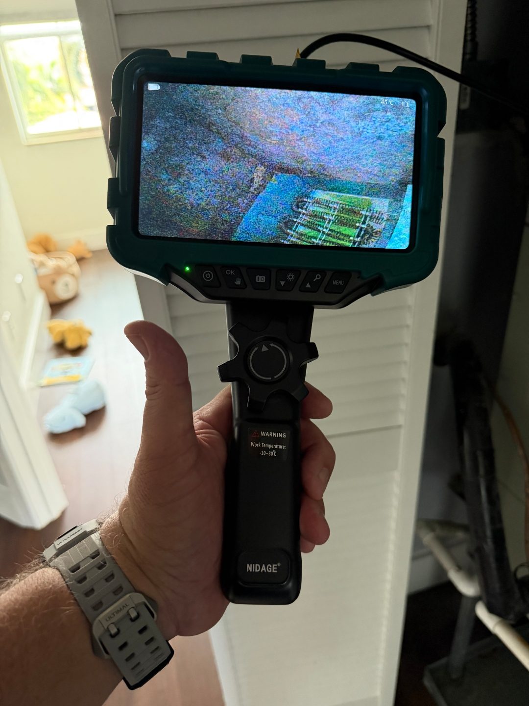 Hand holding a borescope camera near a closet door, a fourth angle of the same coil pattern scan