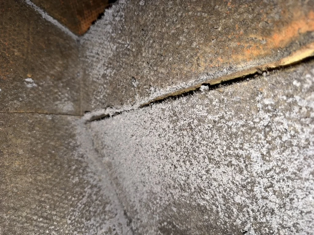 Dark deposits along an internal HVAC insulation seam