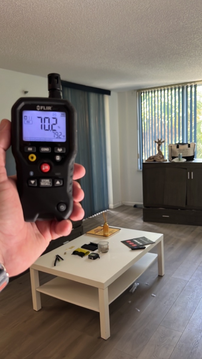 FLIR moisture meter reading 70.2% relative humidity in the living room during the indoor air quality assessment